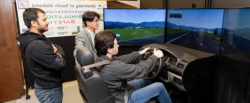 土木工程 students using the driving simulator with professor.